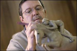 Rick Hadley works on a piece titled "The Jump Off" at his studio in downtown Otterbein. A mold of the clay original is created to make a wax impression. The impression is then used for pouring bronze for the sculpture.